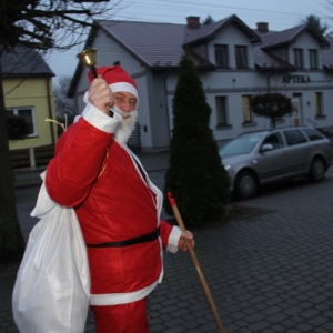 Mężczyzna przebrany za Świętego Mikołaja pozuje do zdjęcia z dzwonkiem.