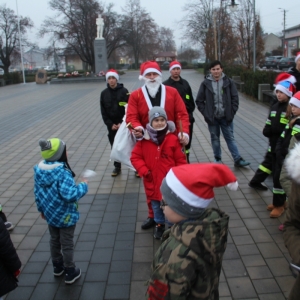 Mężczyzna przebrany za Świętego Mikołaja pozuje z chłopcem do zdjęcia.