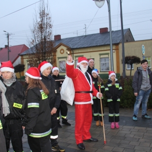 Spotkanie dzieci przebranych za straż pożarną z czapką Mikołaja i pana przebranego za Świętego Mikołaja.