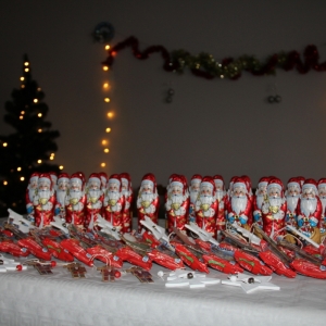 Upominki świąteczne ułożone na stole - słodycze, ozdoby.