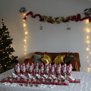 Upominki świąteczne ułożone na stole - słodycze, ozdoby.