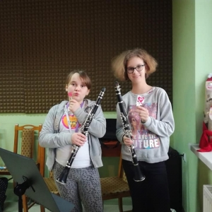 Dwie dziewczynki trzymające po lizaku w kształcie serduszka i instrumenty.